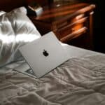 Laptop on neatly made bed