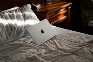 Laptop on neatly made bed