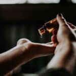 Hands pouring essential oil into palm