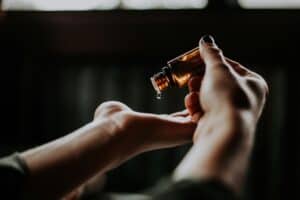Hands pouring essential oil into palm