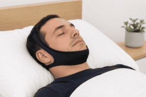 Man sleeping with chinstrap device