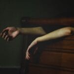arms hanging off of bed during sleep