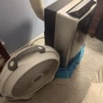 a bedside fan next to a portable AC unit in home