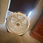 a cooling sleep setup with blackout curtains and a fan