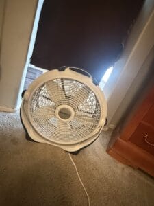 a cooling sleep setup with blackout curtains and a fan