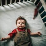 a crib sheet with a child in bed