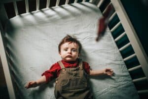 a crib sheet with a child in bed