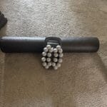 a massage gun next to a foam roller
