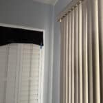 a blackout curtain next to blinds in home