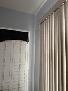 a blackout curtain next to blinds in home