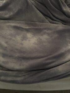 cooling side of blanket laid out on bed