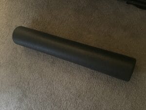 a foam roller for stretching out laid out on floor
