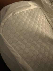 a mattress topper on corner of the bed in home