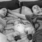 new parents and a baby sleeping