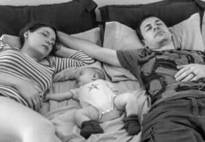 new parents and a baby sleeping