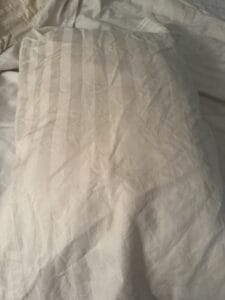 a satin pillowcase on pillow in bed
