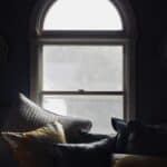 pillows stacked in bedroom by window