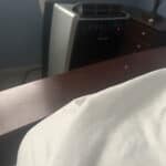a portable ac in bedroom with corner of the bed