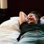 someone laying on bed happy