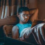 someone reading in bed with glasses
