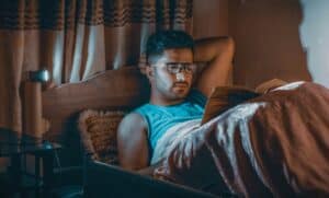 someone reading in bed with glasses