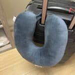 a travel pillow latched on luggage