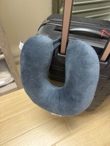 a travel pillow latched on luggage