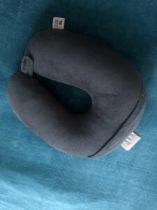 a travel pillow on bed with a U shape for neck