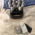 TENS unit with massage gun laying on bed