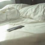 an empty bed with phone on it