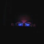 someone wearing blue light glasses at night