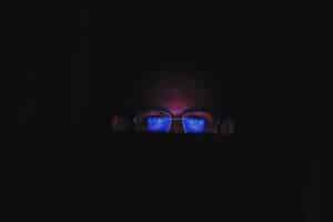 someone wearing blue light glasses at night