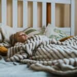 a child under blanket in bed