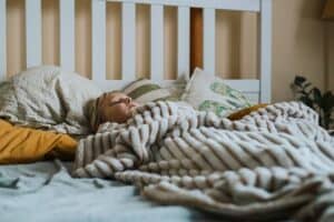 a child under blanket in bed
