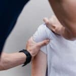 a woman getting her shoulder checked at the doctor