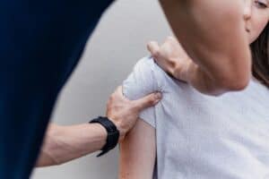 a woman getting her shoulder checked at the doctor
