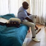 someone getting ready in bedroom unpacking
