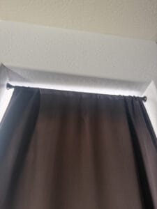 a tension rod holding up blackout curtain