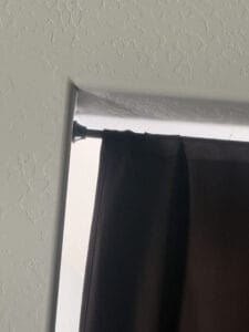 a tension rod on wall for blackout curtains