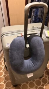 a travel pillow clipped onto luggage
